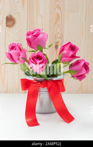Bouquet de tulipes dans un seau en fer avec un noeud rouge Banque D'Images