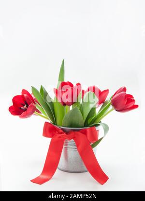 Bouquet de tulipes dans un seau en fer avec un noeud rouge Banque D'Images