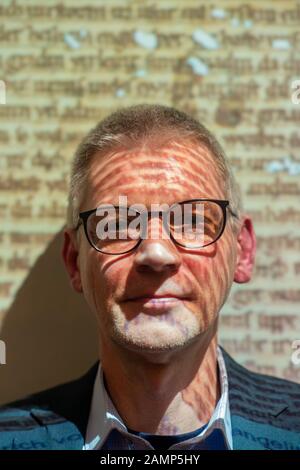 14 janvier 2020, Saxe-Anhalt, Luthéristadt Wittenberg: Matthias Piontek, directeur adjoint de la "bibliothèque de recherche Wittenberg pour l'histoire de la réforme", se trouve devant un écran sur lequel l'image d'un fragment de parchemin est projetée. Le chercheur avait trouvé deux fragments religieux manuscrits uniques en traduction allemande dans l'ancien inventaire de son institution. Les textes sont datés de 1220 et du dernier quart du 13ème siècle. Les deux fragments de parchemin sont venus à la lumière pendant les inspections d'inventaire et ont été utilisés comme reliures de livres. Les pièces peuvent être vues du 21 février au 20 mai Banque D'Images