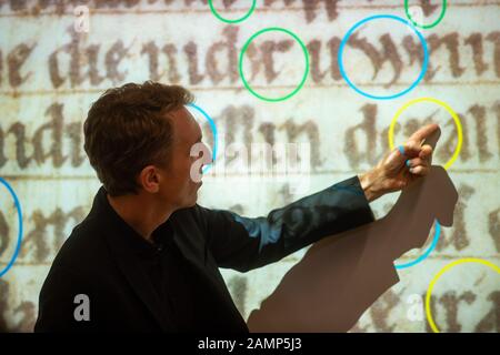 14 janvier 2020, Saxe-Anhalt, Luthéristadt Wittenberg: Christoph Mackert, directeur du Centre des manuscrits de Leipzig, explique comment les fragments de parchemin pourraient être datés par l'orthographe de lettres individuelles. Deux fragments de parchemin religieux manuscrits uniques en traduction allemande ont été trouvés dans l'ancien inventaire de la 'Reformation History Research Library Wittenbergder', daté à l'an 1220 et au dernier quart du 13ème siècle. Les deux fragments sont venus à la lumière lors des inspections de stock et ont été utilisés comme couvertures de livre. Les pièces peuvent être vues du 21 février au 20 mai i Banque D'Images