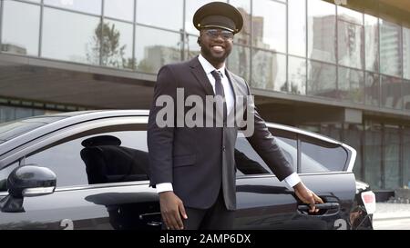 Le chauffeur de taxi VIP ouvrant poliment la porte de la voiture pour son client, le meilleur service Banque D'Images
