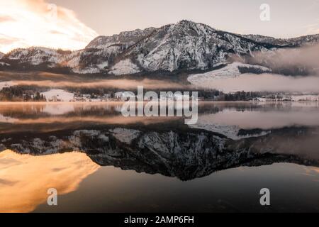 Lac de montagne en hiver avec réflexion au coucher du soleil Banque D'Images