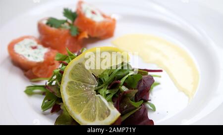 Un plat de départ de restaurant de saumon fumé roulé et de fromage à la crème. Banque D'Images