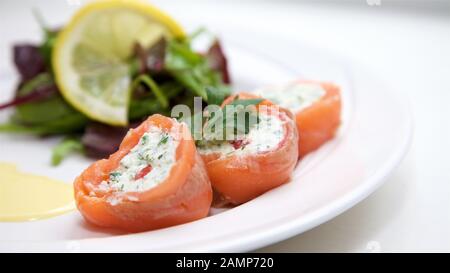 Un plat de départ de restaurant de saumon fumé roulé et de fromage à la crème. Banque D'Images