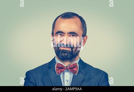 Succès. Gros plan portrait tête tourné beau homme souriant mûr heureux isolé sur fond vert jaune mur. Expression positive du visage de l'émotion humaine Banque D'Images