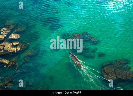 Homme seul sur un bateau dans la mer tropicale Banque D'Images