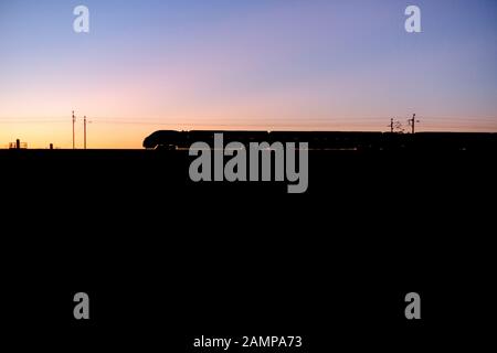 Avanti / Virgin Trains Pendolino Alstom de la côte ouest de faire une silhouette au coucher du soleil sur la ligne principale de la côte ouest. Banque D'Images