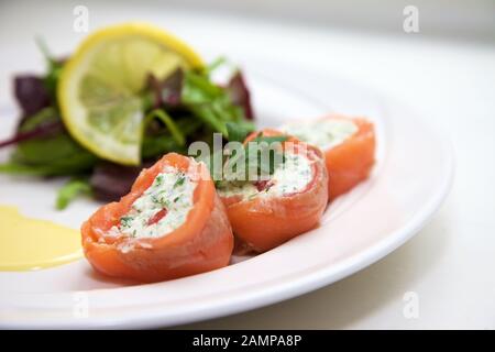Un plat de départ de restaurant de saumon fumé roulé et de fromage à la crème. Banque D'Images
