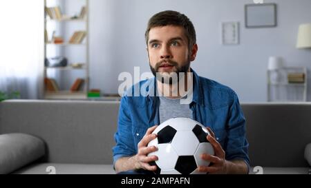 L'homme excité a nervosité à regarder le match de football à la télévision à la maison, fin de la première moitié Banque D'Images