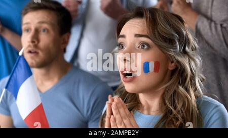 Les supporters français de football qui regardent le jeu final ensemble dans un pub, espoir de victoire Banque D'Images