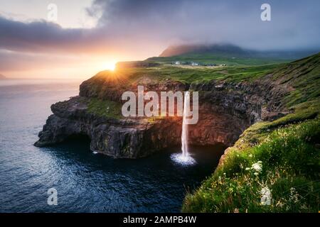 Vue incroyable au coucher du soleil sur la cascade de Mulafossur dans le village de Gasadalur, sur l'île de Vagar des îles Féroé, au Danemark. Photographie de paysage Banque D'Images