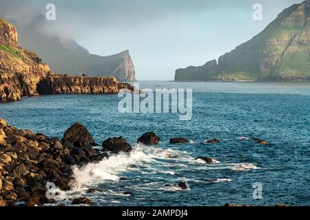 Vue spectaculaire sur les piles de mer de Drangarnir et Tindholmur dans l'océan Atlantique depuis le village de Gasadalur sur l'île de Vagar, aux îles Féroé. Photographie de paysage Banque D'Images
