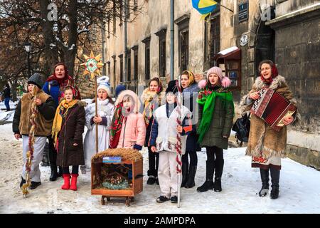 Lviv, Ukraine - 13 janvier 2019: Groupe d'enfants et d'adultes chantant des chants de Noël dans la rue de la ville. Les vacances d’hiver folkloriques de Malanka Banque D'Images