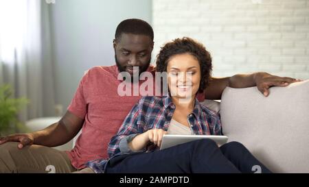 Réservation de billets pour des couples multiraciaux et hôtel sur tablette, planification de vacances en ligne Banque D'Images