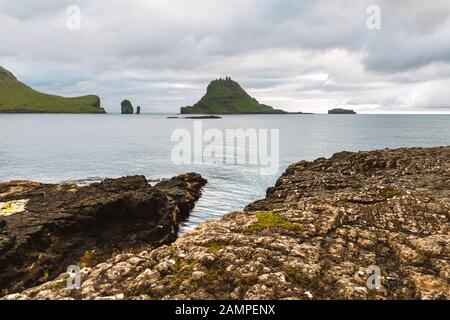 Vue spectaculaire sur les piles de mer de Drangarnir et Tindholmur dans l'océan Atlantique depuis l'île de Vagar, les îles Féroé. Photographie de paysage Banque D'Images