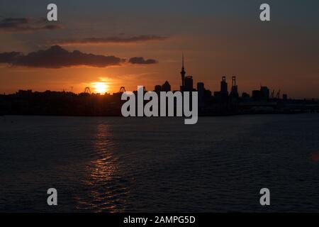 Silhouette de l'Auckland, Nouvelle-Zélande skyline at sunset. Banque D'Images