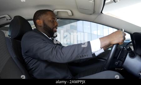 Heureux homme conduisant une nouvelle voiture, excité par un achat réussi, les rêves deviennent réalité Banque D'Images