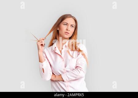 Freestyle. Jeune femme debout isolée sur cheveux de maintien blancs concernés Banque D'Images