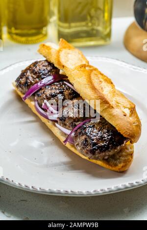 Sandwich Kofte Ekmek / Meatball Turc Avec Oignons Rouges. Restauration Rapide Traditionnelle De La Turquie. Prêt À Manger. Banque D'Images