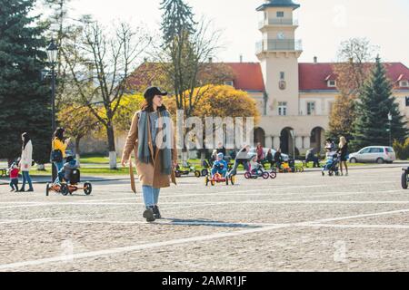 Jolie jeune femme à la mode en marche par la couche brune street Banque D'Images