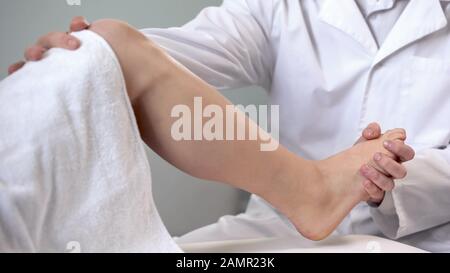 Traumatologue examinant le pied du patient, patient recevant les premiers soins en clinique Banque D'Images