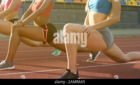 L'équipe féminine de coureurs qui étirent les muscles des jambes avant le marathon, le championnat Banque D'Images