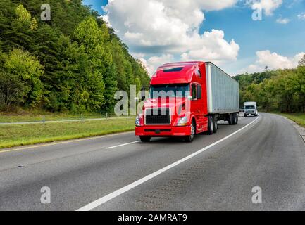 Prise de vue horizontale d'un semi-camion rouge qui descend sur une autoroute interstate. Banque D'Images