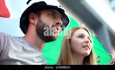 Les supporters italiens de football applaudissant l'équipe nationale, agitant le drapeau national, le jeu final Banque D'Images