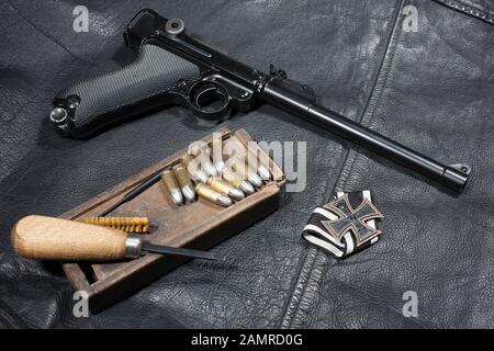 Guerre mondiale I période armée allemande handgun Parabellum 'Artillery Luger' avec ammuniotion et accessoires sur fond de veste en cuir noir Banque D'Images