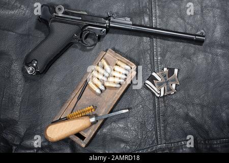 Guerre mondiale I période armée allemande handgun Parabellum 'Artillery Luger' avec ammuniotion et accessoires sur fond de veste en cuir noir Banque D'Images