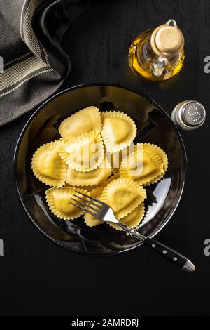 Pâtes italiennes farcies. Panzerotti pâtes sur la plaque sur l'ancienne table de cuisine. Pose plate. Banque D'Images