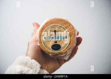 Paris, France - 27 décembre 2019: Main d'homme tenant sur fond blanc délicieux U Pecurino traditionnel fromage corsican fabriqué par Pierucci Banque D'Images