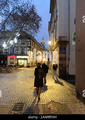 Strasbourg, France - 6 décembre 2018 : vue arrière de la jeune belle femme avec sac à dos marchant sur La Place des Orphelins avec la cathédrale notre-Dame de Strasbourg en arrière-plan Banque D'Images