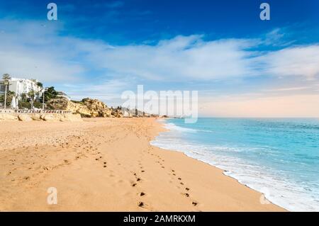 Belle plage de sable et des hôtels dans le village de la station balnéaire d'Albufeira, destination touristique populaire en Algarve, Portugal. Des mouettes sur une large plage de Praia de Al Banque D'Images