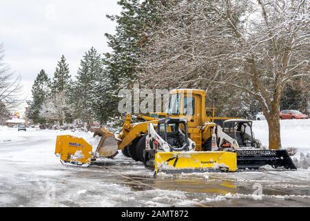 Les véhicules de chasse-neige sont vides dans un parking après une tempête hivernale dans les montagnes du nord de l'Idaho, aux États-Unis. Banque D'Images