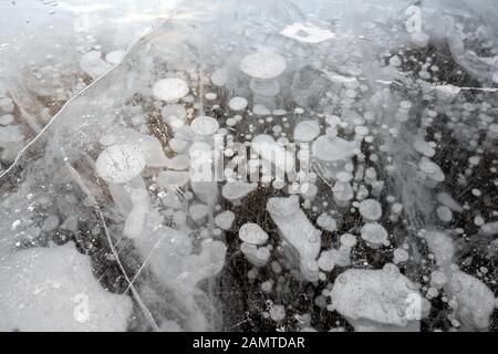 Des bulles de méthane piégées se sont gelées dans l'eau sous la glace épaisse fissurée et repliée sur le lac Abraham Banque D'Images