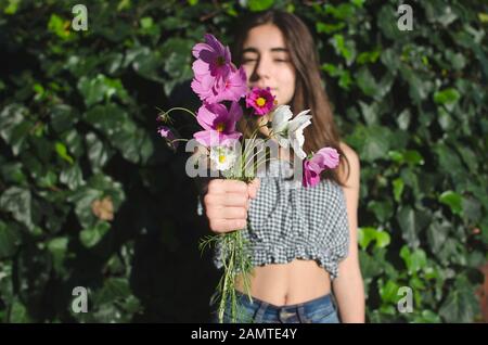Gros plan d'une adolescente qui contient un bouquet de fleurs, l'Argentine Banque D'Images