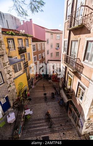 Lisbonne, Portugal - 11 mars 2016 : des immeubles d'appartements jettent des ombres sur une allée escarpée et escarpée sur une colline du quartier Baixa de Lisbonne. Banque D'Images