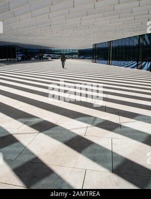 Lisbonne, Portugal - 11 mars 2016 : les piétons traversent des ombres rayées qui ombragent partiellement la nouvelle place publique dans les bureaux d'entreprise d'Ener Banque D'Images