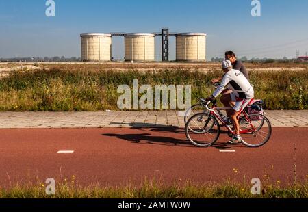 Amsterdam, Pays-Bas - 2 octobre 2011 : deux cyclistes traversent une voie de la zone urbaine de régénération du Zeeburgereiland par le bateau post-industriel Banque D'Images