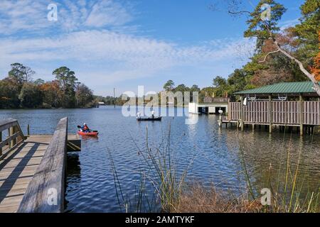 Les pêcheurs dans un bateau et un homme dans un kayak sur la rivière Magnolia Magnolia Springs relaxant en Alabama, Etats-Unis. Banque D'Images