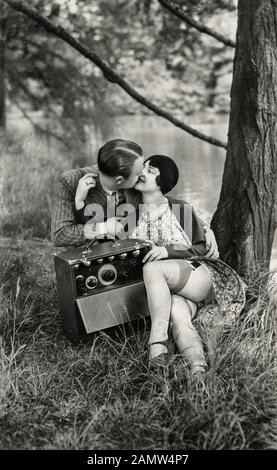 Scène de flapper dans les années 1920 - un homme et une femme embrassent dans les bois Banque D'Images