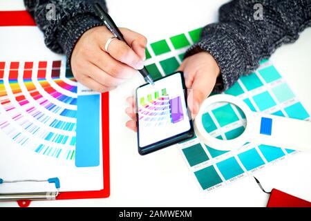 Photo de pantone avec les mains de l'homme à choisir des couleurs. Isolé sur fond blanc. Banque D'Images
