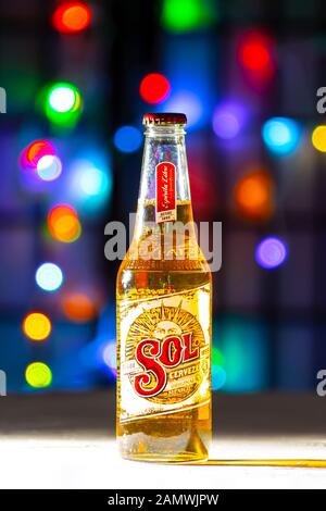 Une bouteille de bière Sol. Une bière mexicaine sur une surface texture blanche sur un flou artistique coloré lumières Banque D'Images