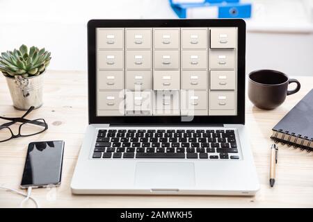 Archivage numérique de fichiers, concept de stockage de données. Armoires de classement sur un écran d'ordinateur portable, arrière-plan de bureau d'affaires Banque D'Images