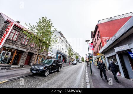 Reykjavik, Islande - 19 juin 2018 : les touristes marchant sur le trottoir de rue dans le centre-ville par des magasins avec des panneaux en été Banque D'Images