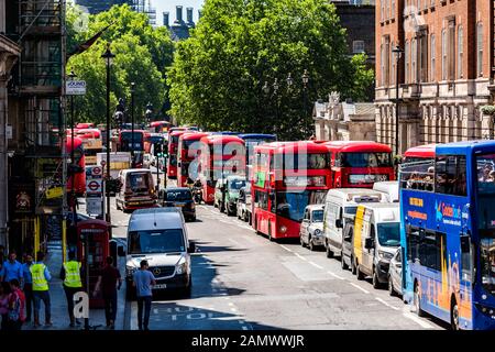 Londres, Royaume-Uni - 22 juin 2018 : vue panoramique sur la rue avec une rangée de nombreux bus rouges et bleus à impériale au centre-ville par Trafalgar Square Banque D'Images