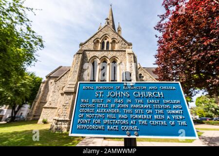 Londres, Royaume-Uni - 24 juin 2018 : l'architecture anglicane de l'église St John the Baptist en été vert jour ensoleillé avec un panneau de proximité à Kensington Banque D'Images