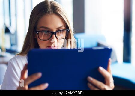 Photo d'une femme focalisée à l'aide d'une tablette numérique Banque D'Images