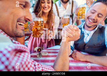 Amis bavarois pratiquant l'art de Arm wrestling Banque D'Images
